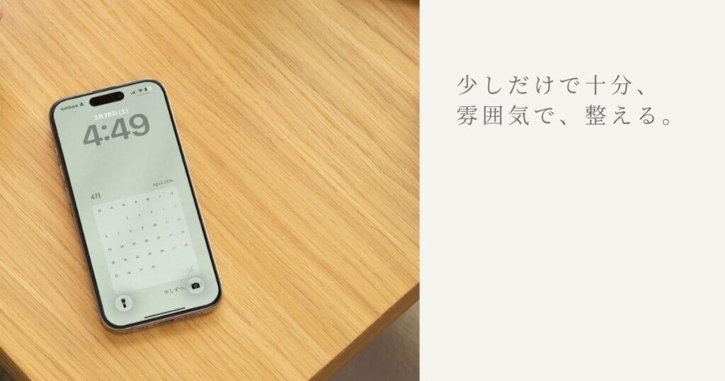 デスクにおいたスマホに設定した4月壁紙（ひかえめ）の使用イメージ